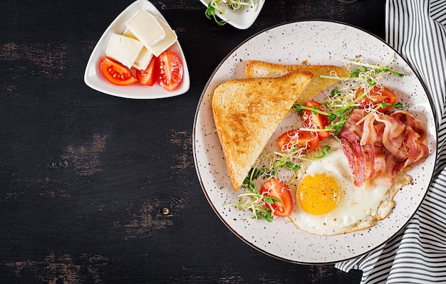 toast, egg, bacon and tomatoes and microgreens salad.