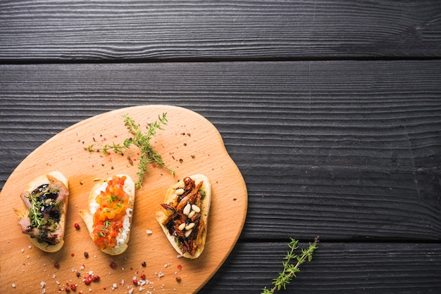 Free photo toast sandwiches with thyme and red peppercorn seed on chopping board