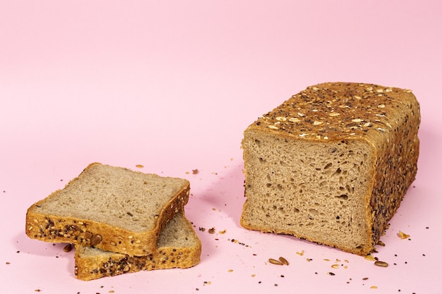 Пшеничный хлеб тоста, нарезанный хлопьями, изолированные на фоне цветов. Premium Фотографии
