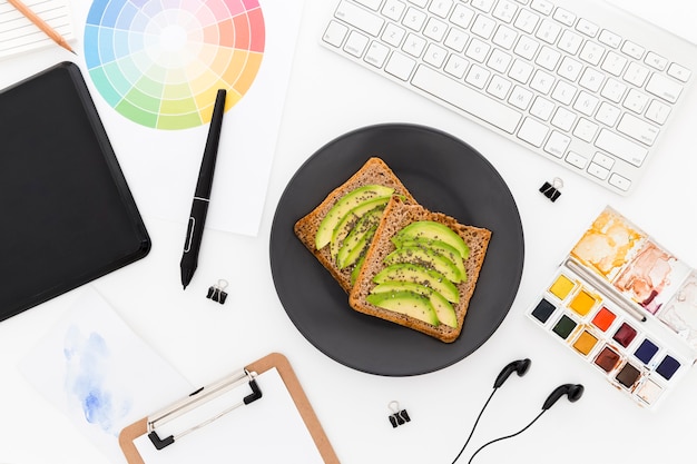 Foto gratuita toast con avocado per colazione in ufficio