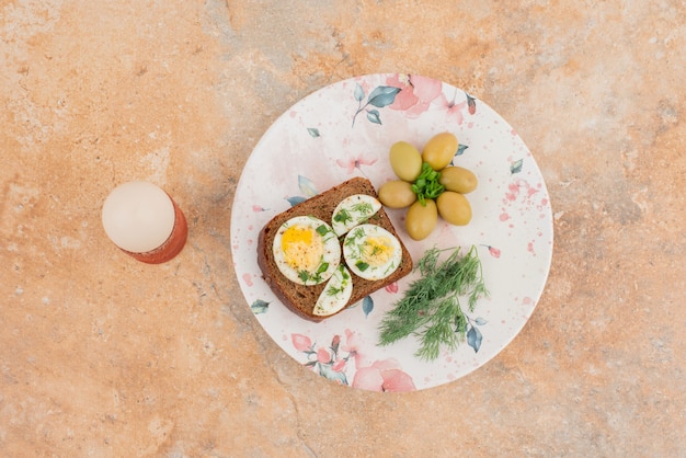 Toast with boiled eggs on marble table