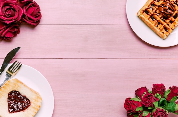 Toast with jam in heart shape with Belgian waffle and roses 