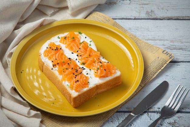 Toast con salmone affumicato e crema di formaggio su un tavolo di legno