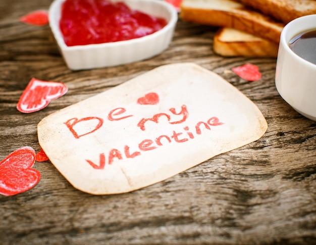Toast with strawberry jam Be My Valentine white message card with coffee Valentine's Day