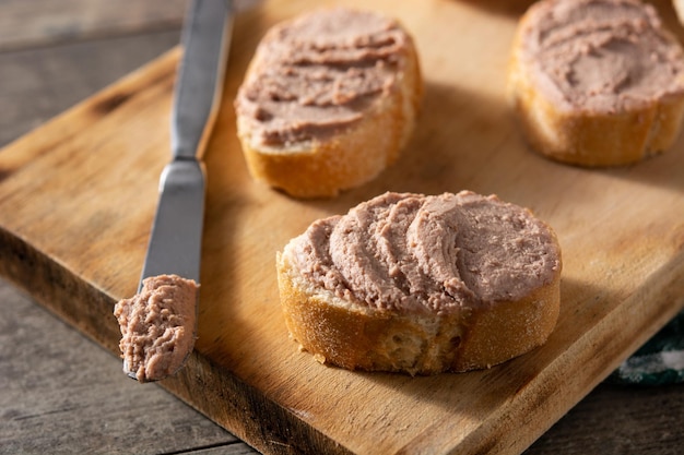 Toasted bread with pork liver pate on wooden table