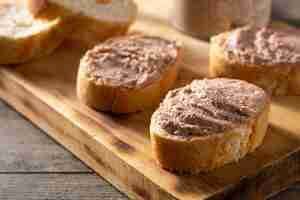 Foto gratuita pane tostato con patè di fegato di maiale su tavola di legno