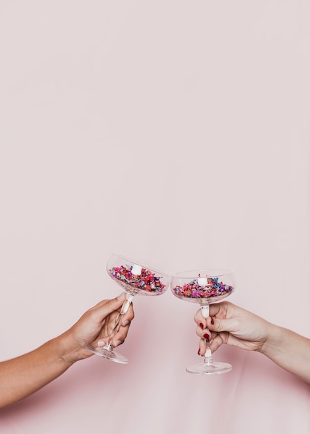 Free photo toasting with confetti filled glasses