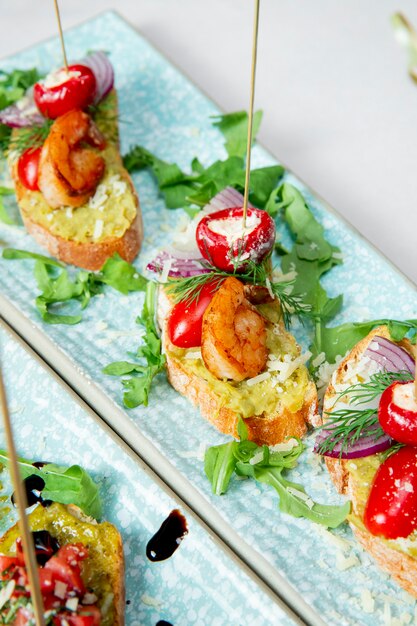 Toasts with shrimps tomatoes onions and greens