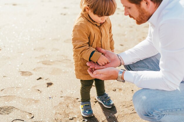 Toddler in coat playing with dad