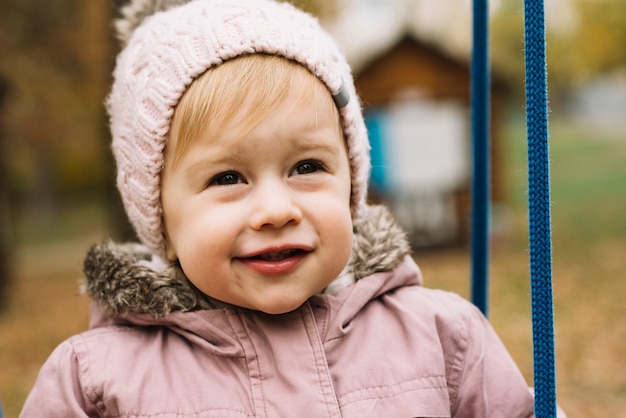 Free photo toddler girl in autumn park looking ahead