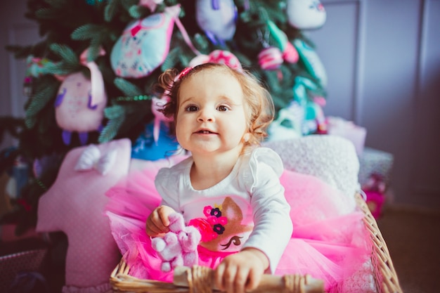 "Toddler girl sitting in baby bassinet"