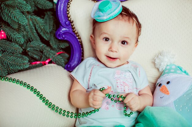 "Toddler playing with garland sitting"