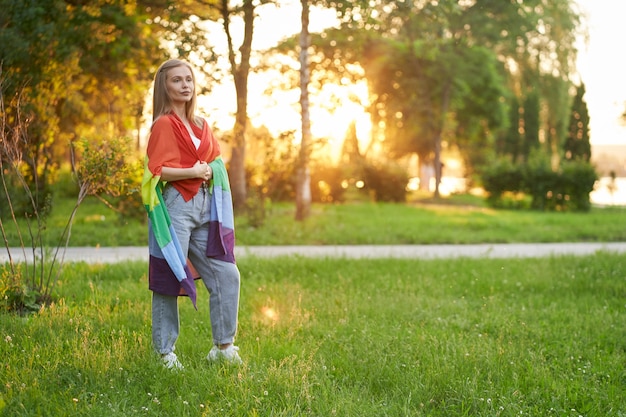 Tolerant woman holding lgbt flag on shoulders