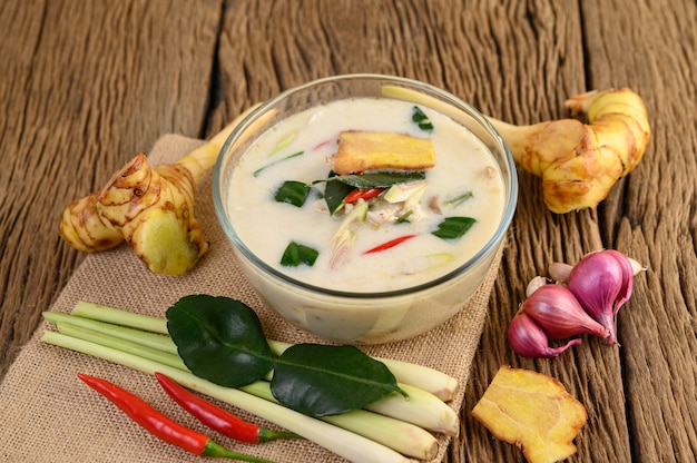 Tom Kha Kai в миске с листьями кафрского лайма, лемонграссом, красным луком, галангалом и перцем чили.