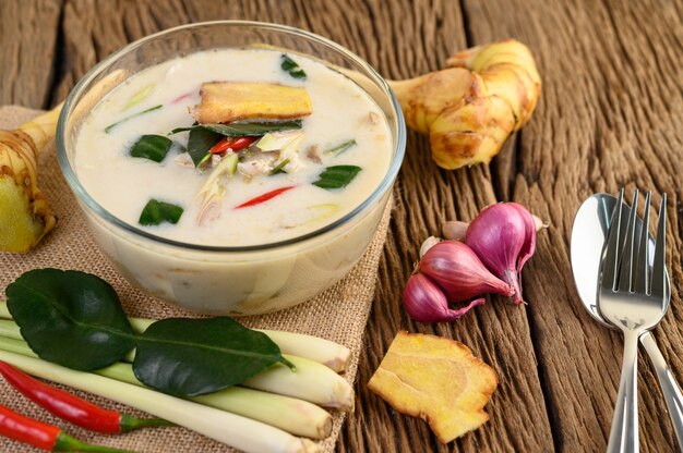 Tom Kha Kai в миске с листьями кафрского лайма, лемонграссом, красным луком, галангалом и перцем чили.