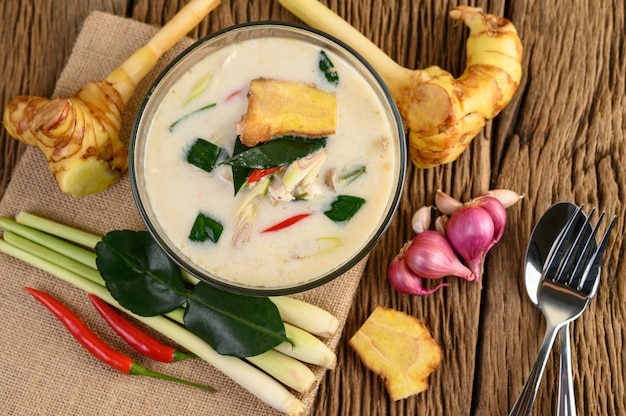 Free photo tom kha kai in a bowl with kaffir lime leaves, lemongrass, red onion, galangal and chilli.