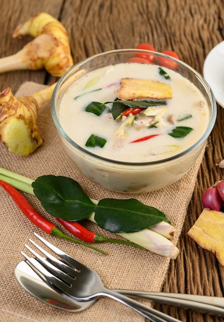 Tom Kha Kai в миске с листьями кафрского лайма, лемонграссом, красным луком, галангалом и перцем чили.