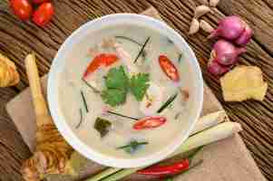 Free photo tom kha kai in a bowl with kaffir lime leaves, lemongrass, red onion, galangal and chilli.