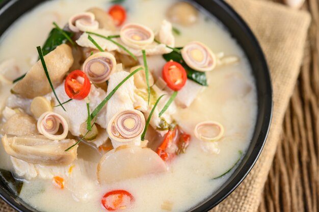 Tom Kha Kai in a pan frying with kaffir lime leaves, lemongrass, red onion, galangal and chilli.