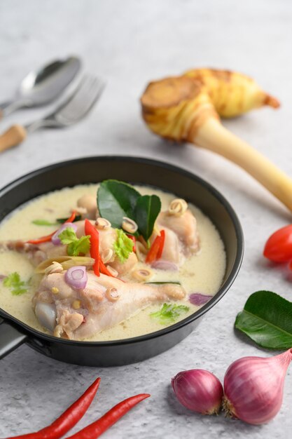 Tom Kha Kai in a pan frying with kaffir lime leaves, lemongrass, red onion, galangal and chilli.