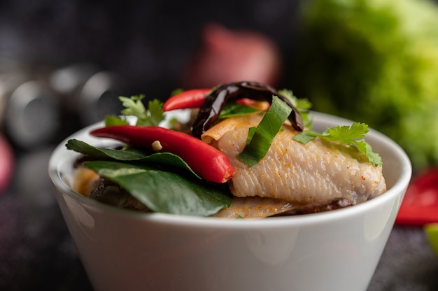 Tom yum chicken with chili, coriander, dried chili, kaffir lime leaves, mushroom and lemongrass in a bowl