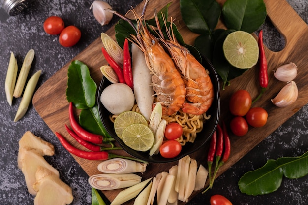 Foto gratuita tom yum kung in una ciotola con pomodoro, peperoncino, citronella, aglio, limone e foglie di lime kaffir