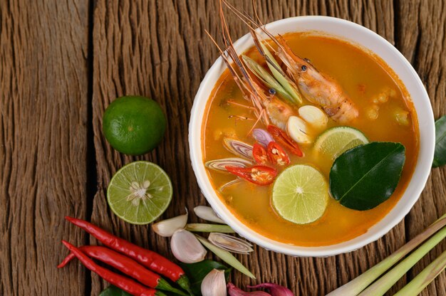 Tom Yum Kung Тайский горячий острый суп из креветок с лимонной травой, лимоном, галангалом и чили на деревянном столе, таиландская еда