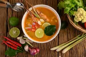 Free photo tom yum kung thai hot spicy soup shrimp with lemon grass,lemon,galangal and chilli on wooden table, thailand food