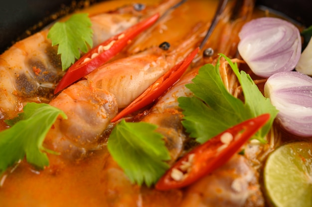 Tom Yum Kung Thai hot spicy soup shrimp with lemon grass,lemon,galangal and chilli on wooden table, Thailand Food