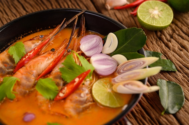 Free photo tom yum kung thai hot spicy soup shrimp with lemon grass,lemon,galangal and chilli on wooden table, thailand food