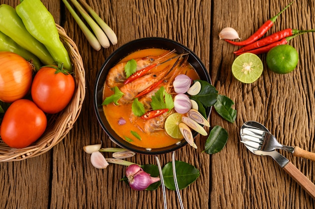 Tom Yum Kung Тайский горячий острый суп из креветок с лимонной травой, лимоном, галангалом и чили на деревянном столе, таиландская еда