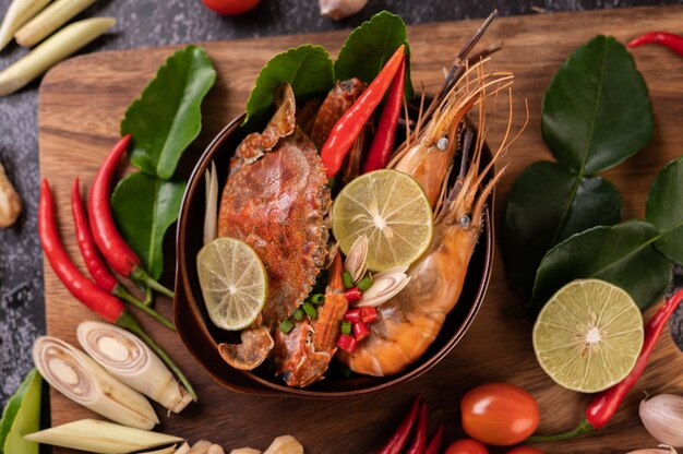 Tom yum with shrimp and crab with lime, chili, tomato, garlic, lemongrass and kaffir lime leaves.