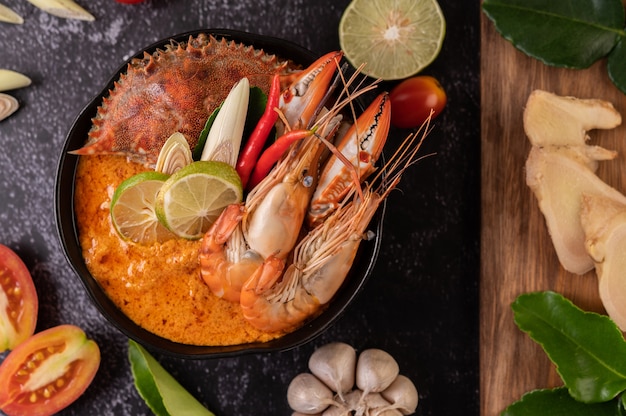 Tom yum with shrimp and crab with lime, chili, tomato, garlic, lemongrass and kaffir lime leaves.