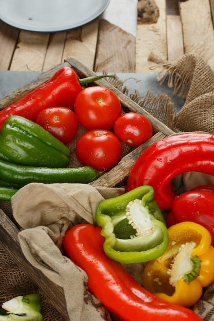 Tomato, cucumber and peppers in a rustic tray. Top view.