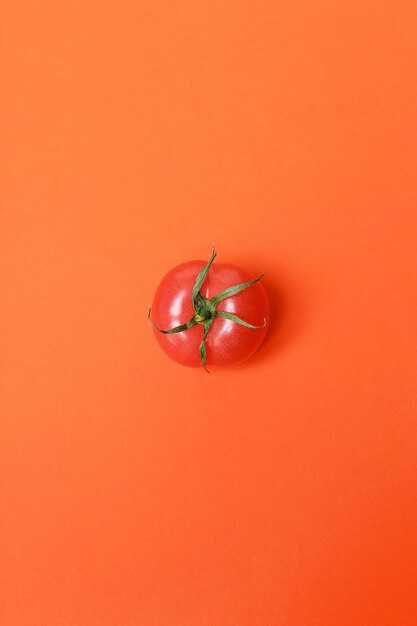 Tomato isolated on red surface