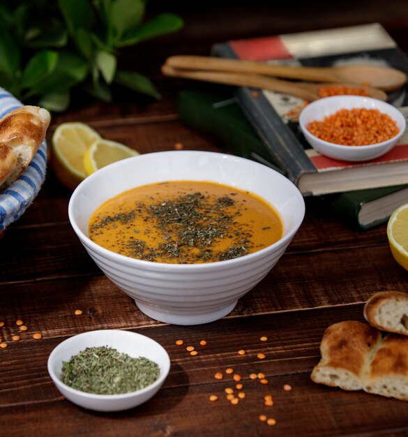 Tomato lentil soup with herbs in a white bowl