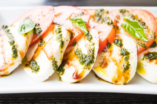 Free photo tomato and mozzarella cheese salad in white plate