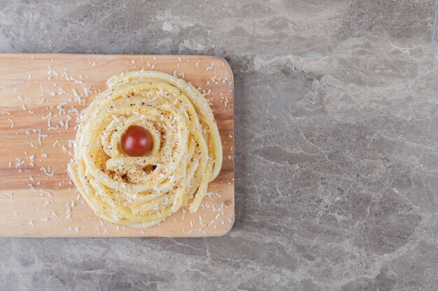 Tomato and pasta on the cutting board , on the marble.