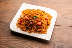 tomato rice also known as tamatar pilaf or pulav made using basmati rice, served in a bowl. selective focus