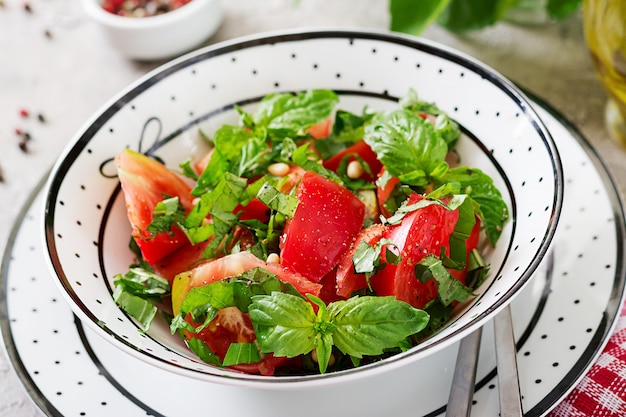 Foto gratuita insalata del pomodoro con basilico e pinoli in ciotola - aperitivo vegetariano sano dell'alimento biologico di dieta vegana.