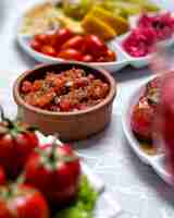 Foto gratuita insalata del pomodoro con il basilico della cipolla di verdure nella vista laterale del piatto di argilla