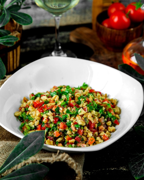 Free photo tomato salad with parsley walnut green and red bell pepper