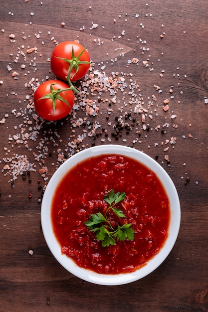 무료 사진 토마토 소스와 체리 토마토는 갈색 돌 표면에 후추 가루를 뿌렸다.