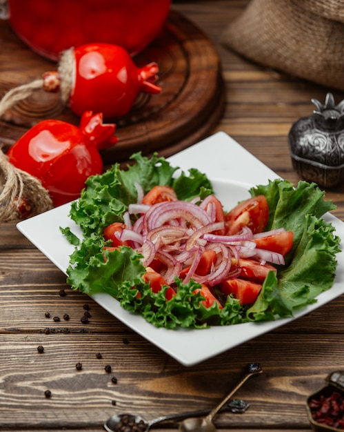 Tomato slices with onion and lettuce leaf.