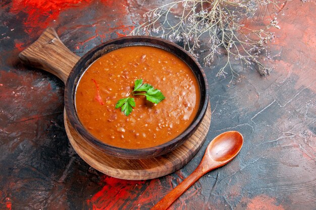 茶色のまな板にトマトスープ、混合色のテーブルにスプーン