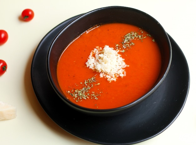 Foto gratuita zuppa di pomodoro ed erbe aromatiche con formaggio in cima