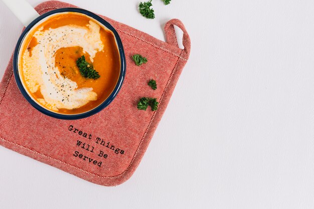 Tomato soup on placemat against white background