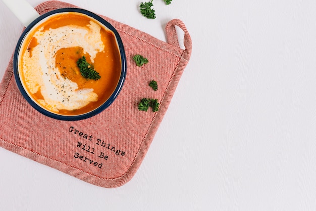 Tomato soup on placemat against white background