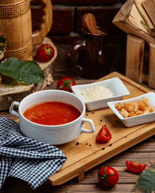 tomato soup served with bread stuffing and grated parmesan cheese
