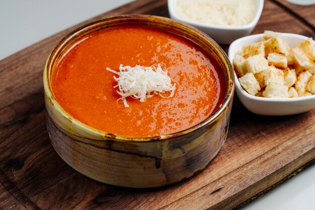 치즈와 사이드 크래커를 얹은 토마토 수프